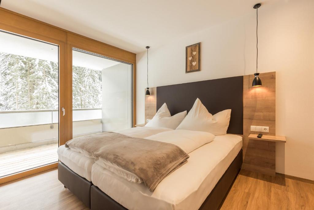 厄茨Apartment Waldesruh的一间卧室设有一张大床和大窗户