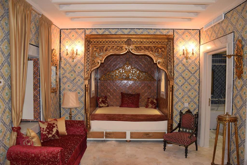 凯鲁万Dar ALOUINI的一间卧室配有一张床、一把椅子和一张沙发