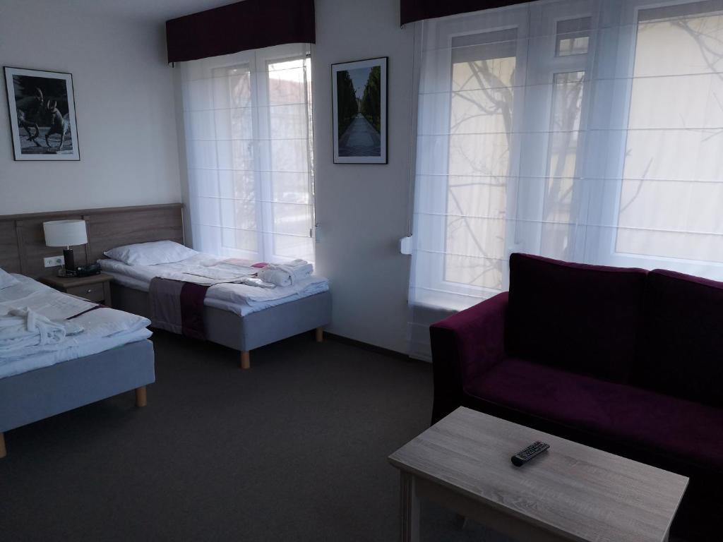 波兹南WILla Medica的酒店客房,设有两张床和一张沙发