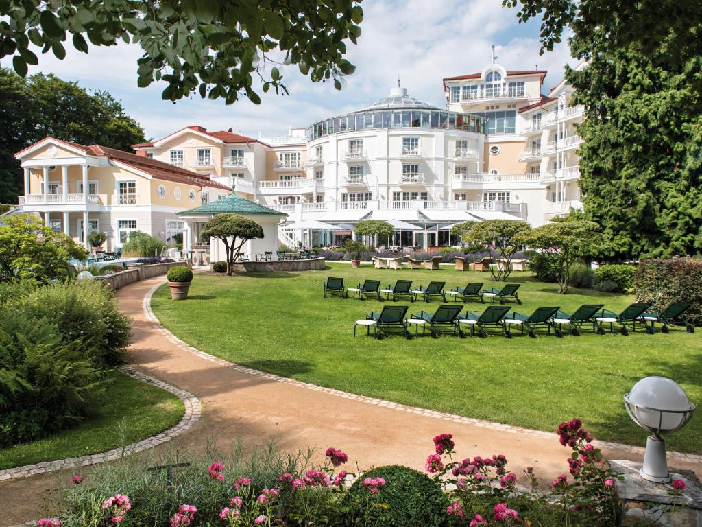 黑灵斯多夫海林斯多夫斯坦迪夏姆旅行酒店的公园里一座带椅子的大型白色建筑