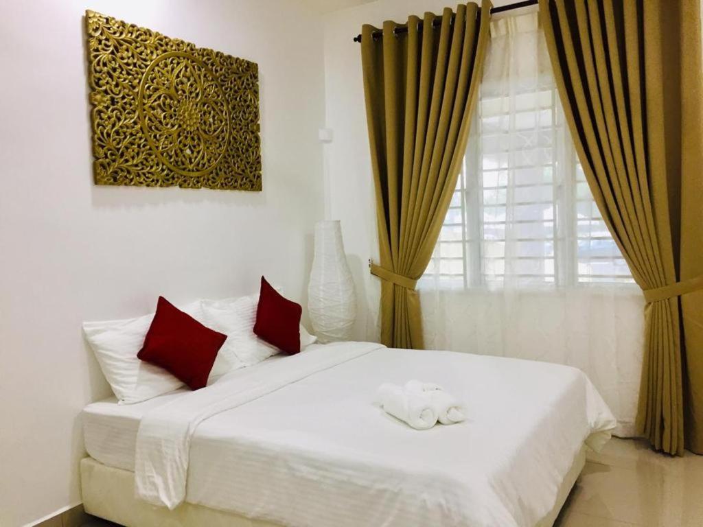 JertihAisya homestay jerteh的卧室配有白色的床、红色枕头和窗户