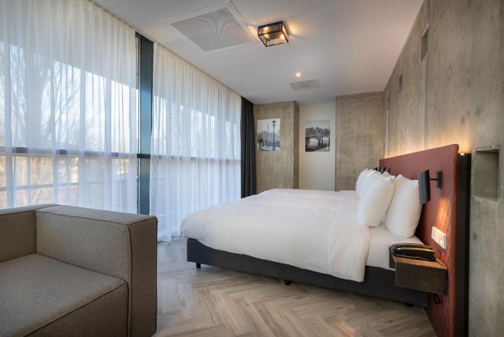 阿姆斯特丹Hotel New Kit的一间卧室配有一张床、一把椅子和一张沙发