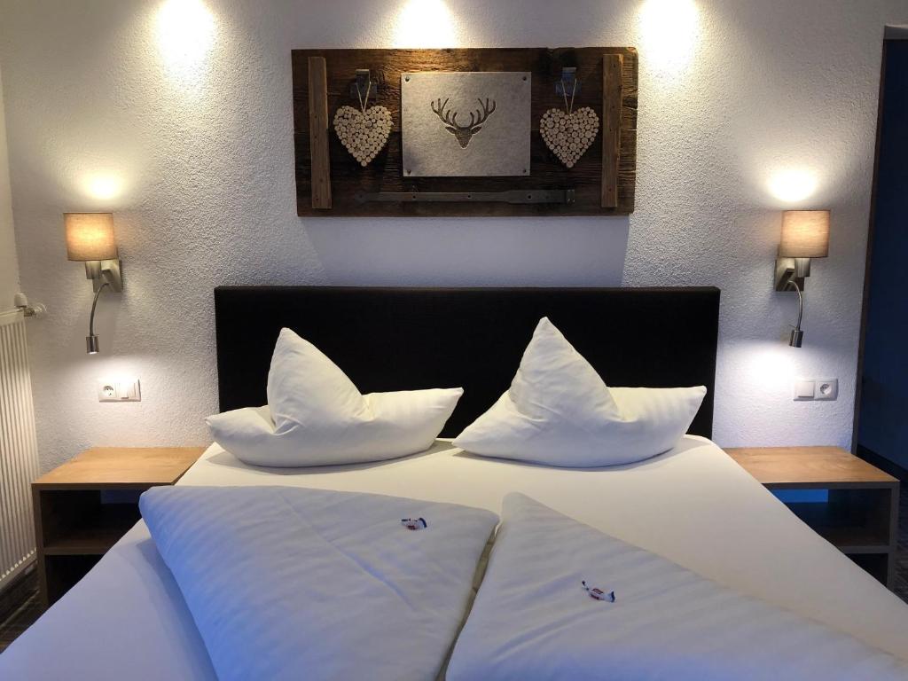 绍滕斯哈克尔宾馆的一间卧室配有带白色床单和枕头的床。