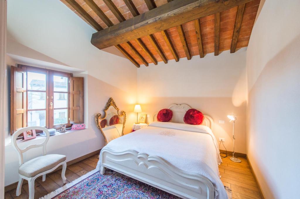 卡尔米尼亚诺podere Sanlorenzo的一间卧室配有一张带两把椅子的床和一扇窗户