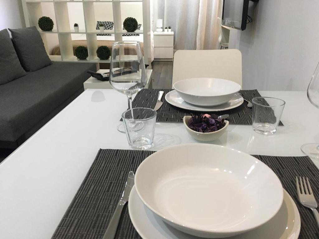 瓦伦西亚Zerka Centro的餐桌,带盘子和玻璃杯,沙发