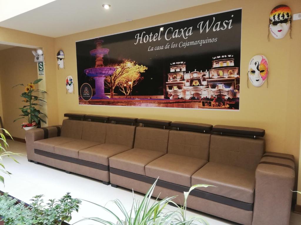 卡哈马卡Hotel Caxa Wasi的一张沙发,放在一个等候室,墙上有标志