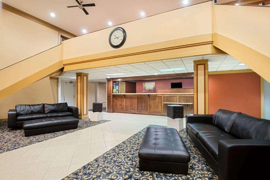 费利蒙弗里蒙特戴斯酒店的大厅配有沙发和墙上的时钟