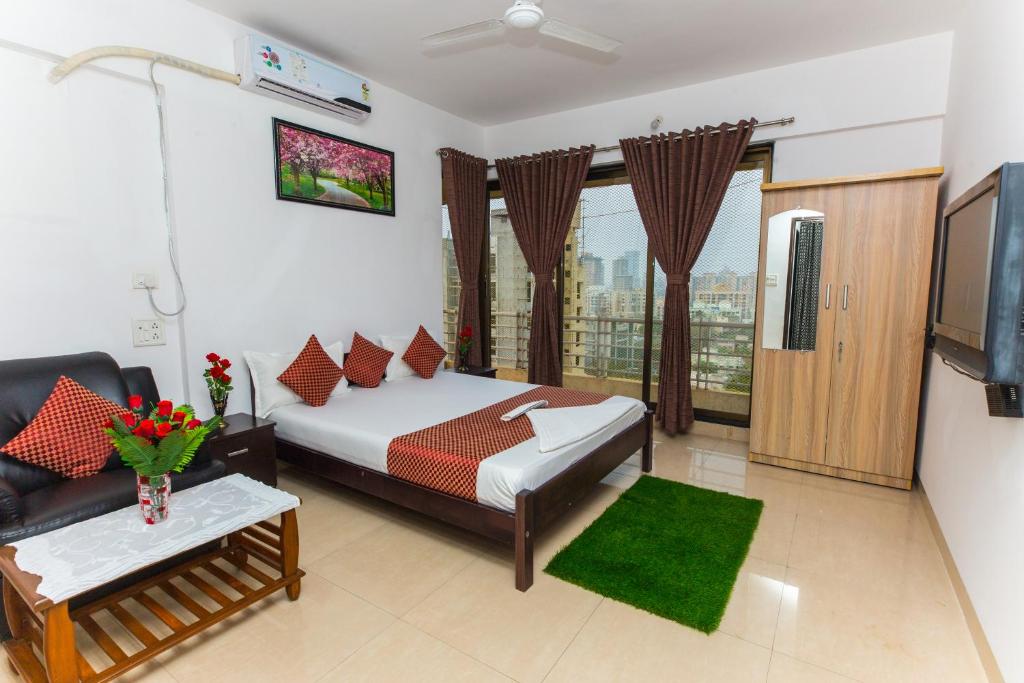 孟买Aristo Hospitality Services Apartment, 1402,14th Floor的一间卧室配有一张床、一张沙发和一台电视。