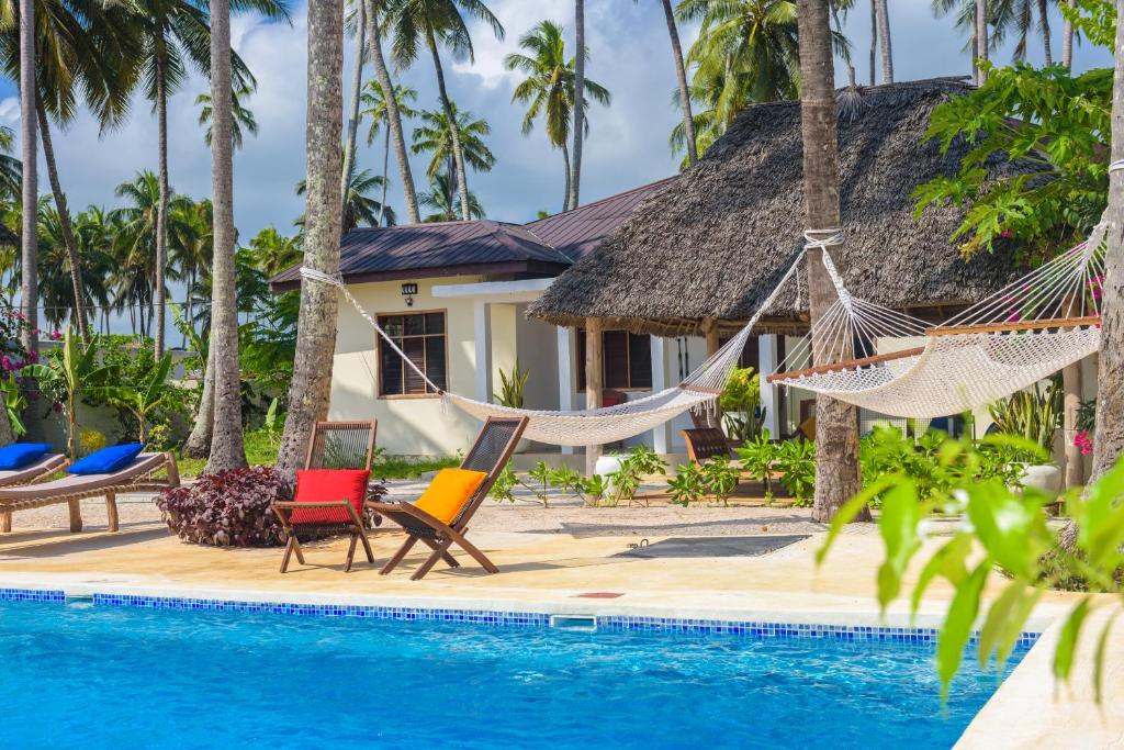 吉汶瓦Magic Beach Villa的一个带游泳池和吊床的度假胜地