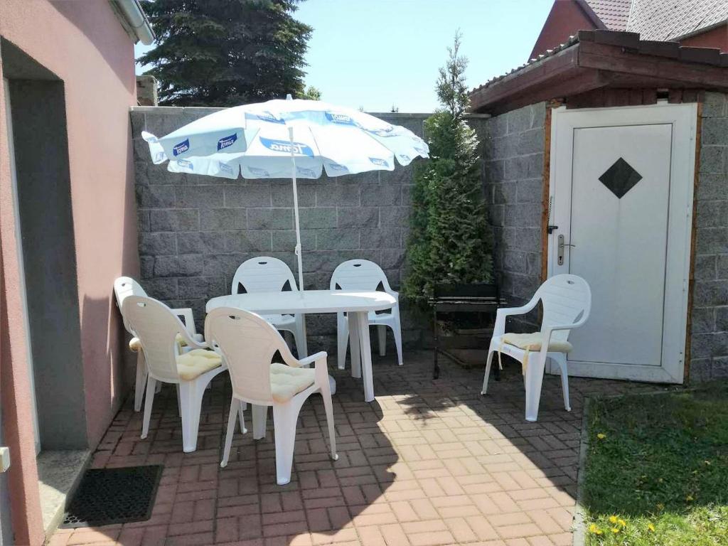 MěděnecComfy Holiday Home near Forest in Medenec的庭院里配有桌椅和遮阳伞