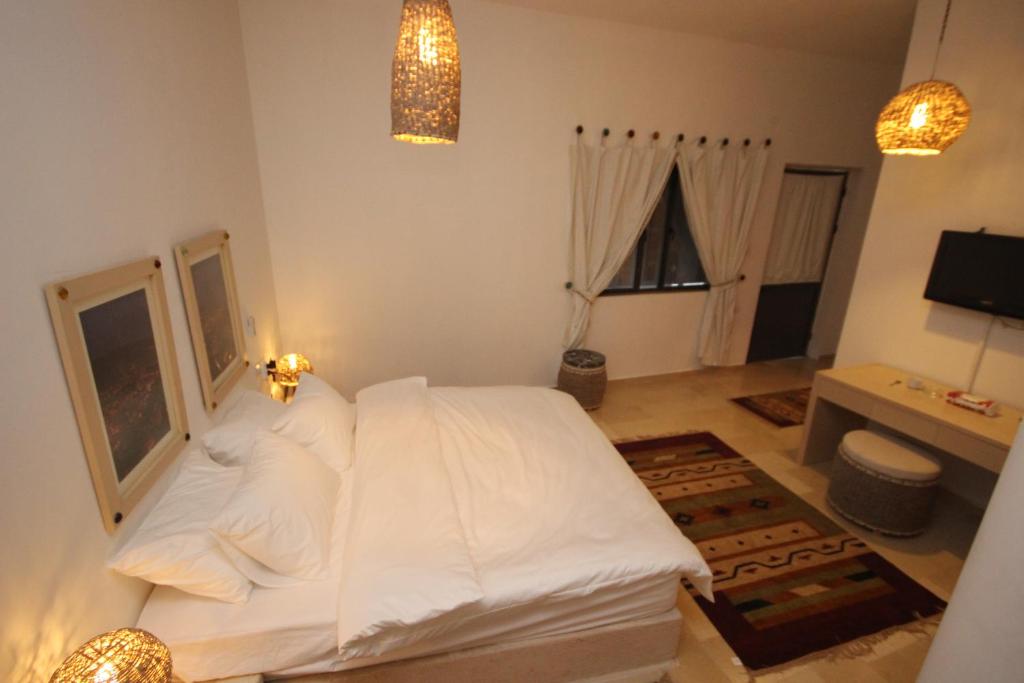 纳布卢斯Khan Alwakala Hotel的卧室配有一张白色大床