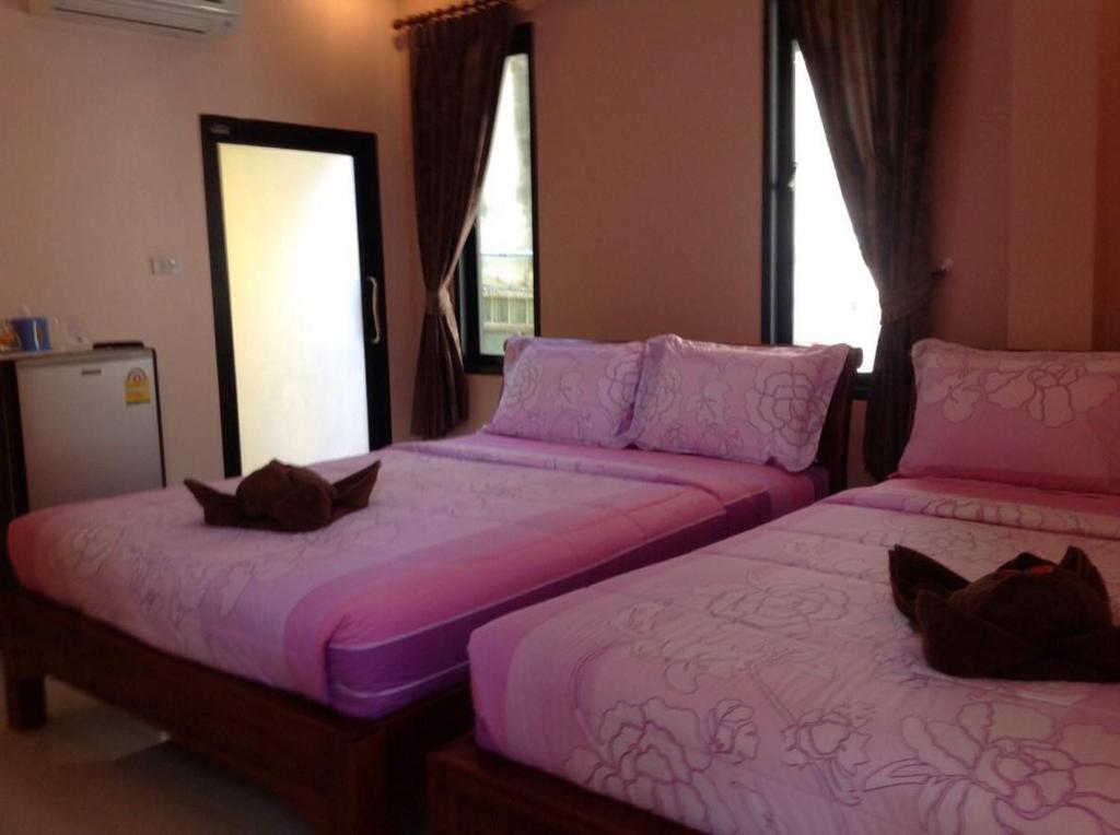 沙美岛Baan Mulan的配有粉红色床单的客房内的两张床