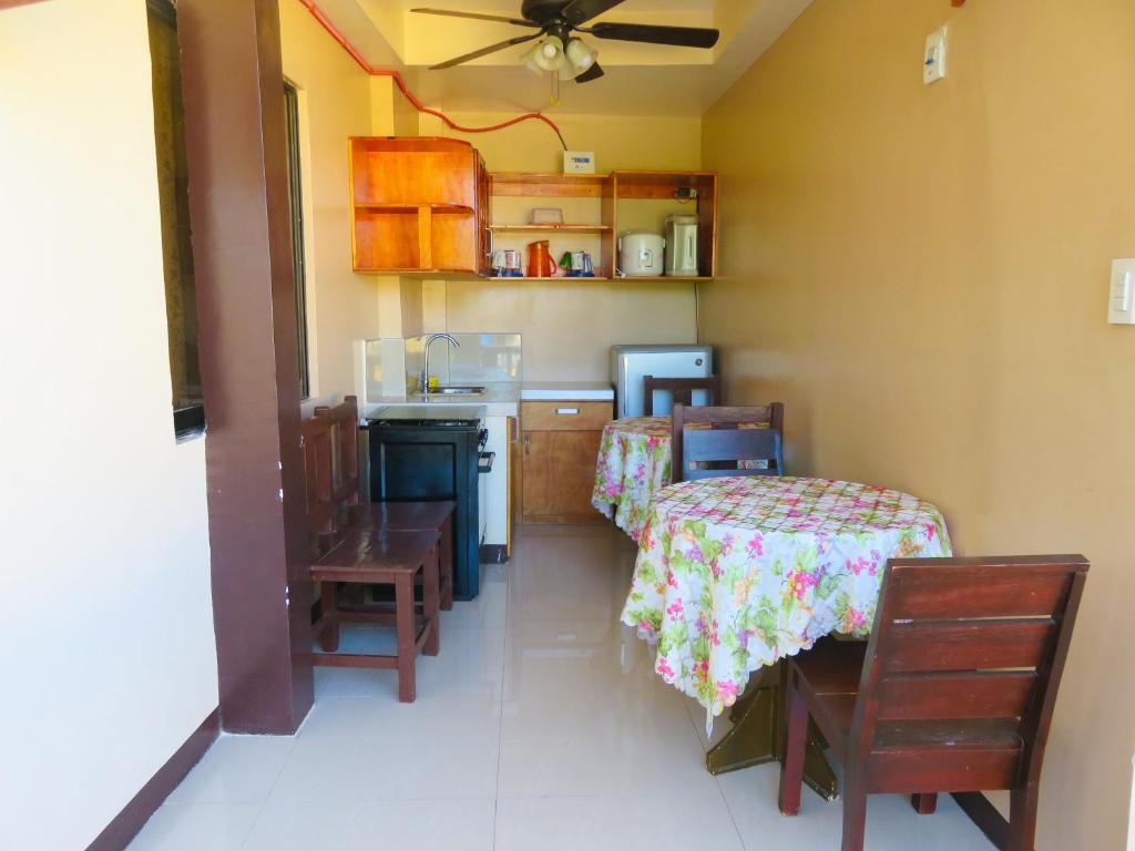 班塔延岛纳内特游客宾馆的厨房配有两张床和一张桌子及椅子