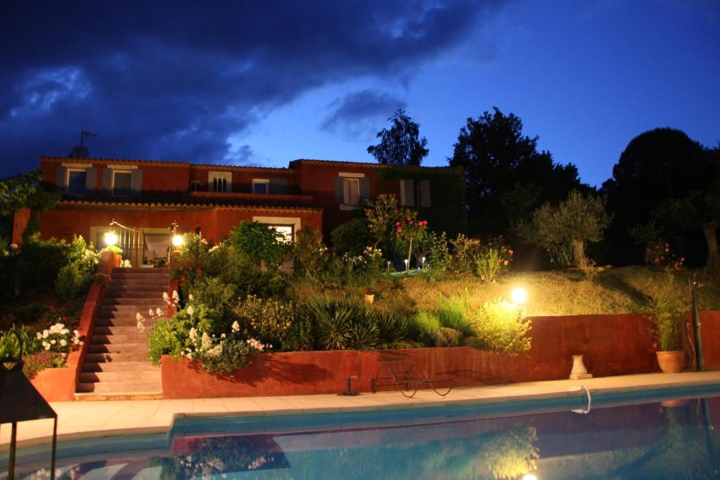 鲁西永玫瑰别墅酒店的一座晚上设有游泳池的房子