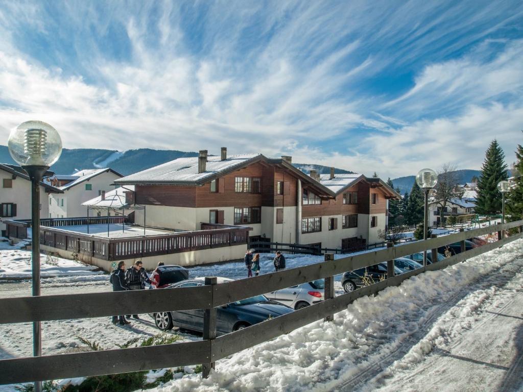 福尔加里亚Hotel Villaggio Nevada的一群人站在房子前面的雪中