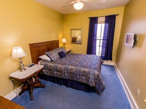 伊利Victoria Inn的一间卧室配有一张床、一张桌子和一个窗户。