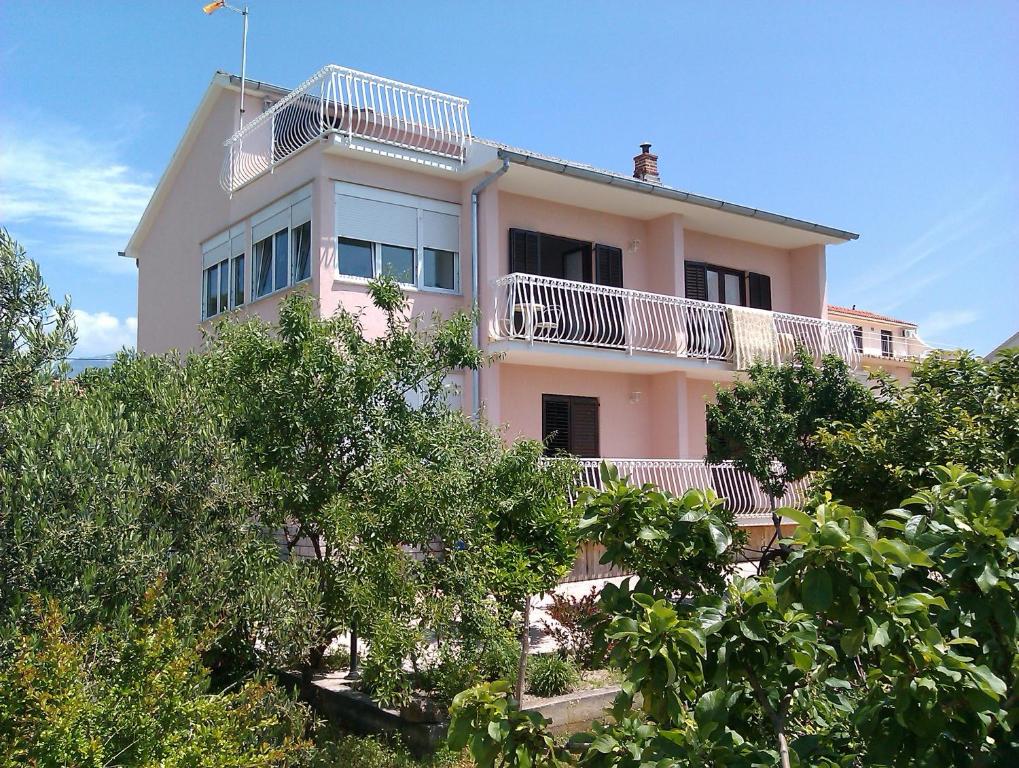 巴尔巴特纳拉布Rooms Marija的粉红色的房子,上面设有阳台