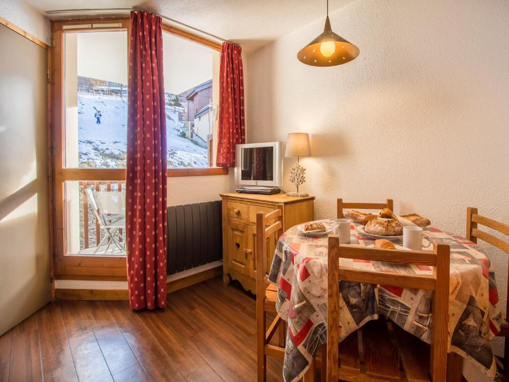 佩塞克鲁瓦26 Praz de l'Ours Vallandry - Paradiski的一间带桌子和窗户的用餐室