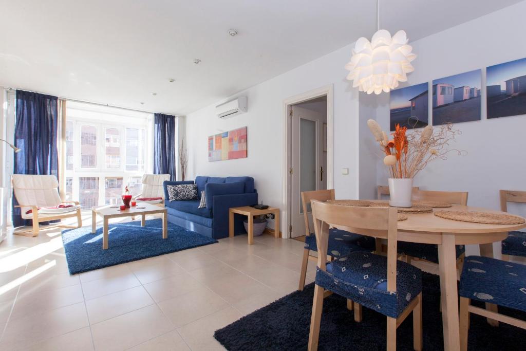 马德里Ribera的客厅配有桌子和蓝色沙发