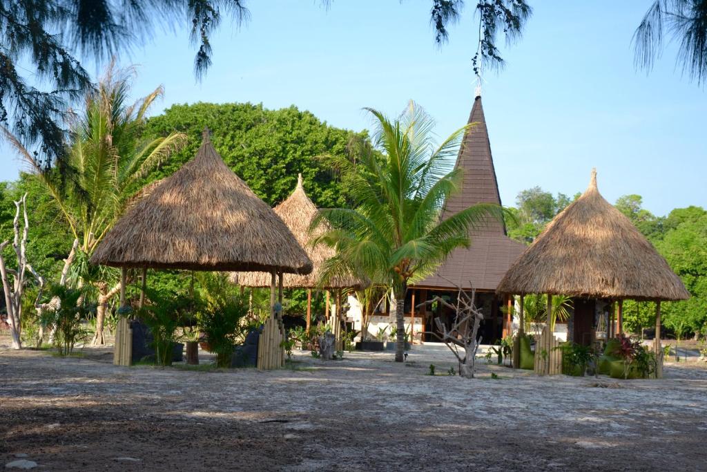 RindiEcoresort Sumba Dream的一群树和棕榈树的小屋