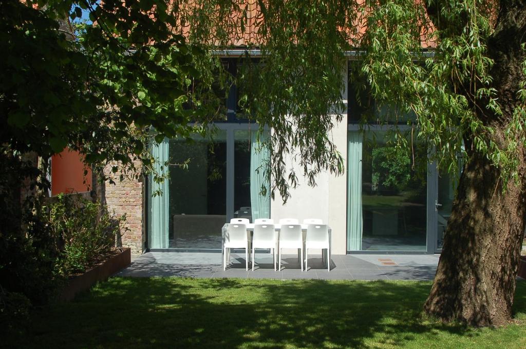 Lo-ReningeHet Wagenhuis的坐在大楼前的三把白色椅子