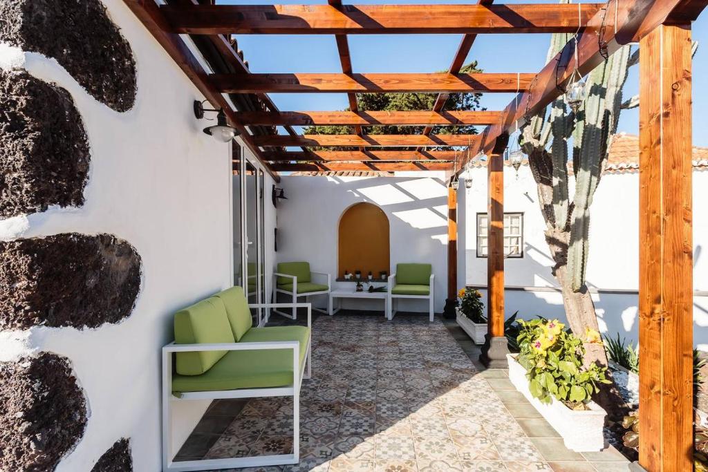埃尔帕索Bungalow Los Laureles的一个带绿色椅子的庭院和木制凉亭