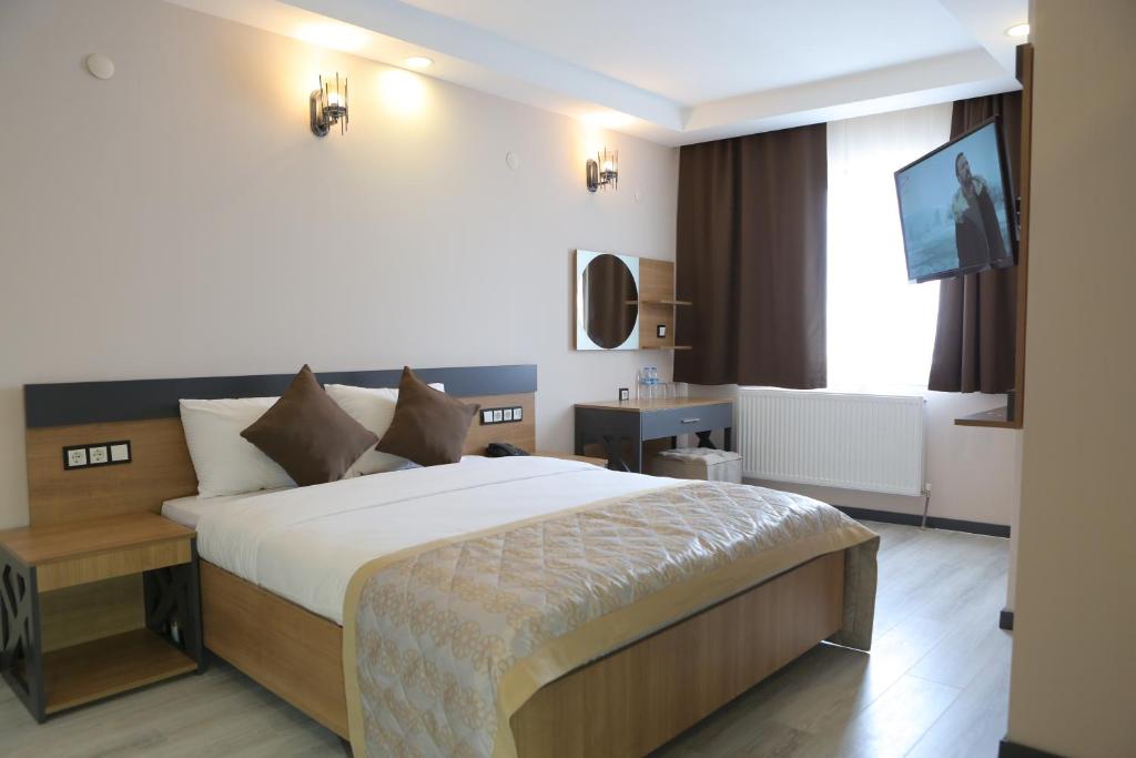 梅尔济丰KORKMAZ OTEL的酒店客房,配有床和电视