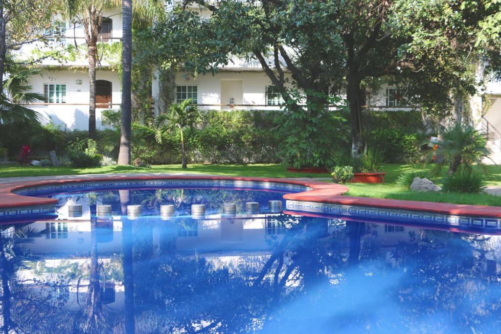 瓜达拉哈拉金叶酒店及套房 的一座位于庭院内的游泳池,其建筑背景为: