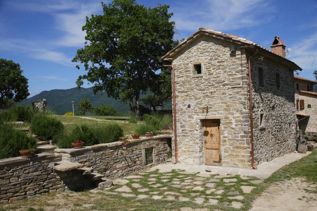 CerbaioloI Poggi di Belvedere的一座小石头建筑,在院子里有一扇门