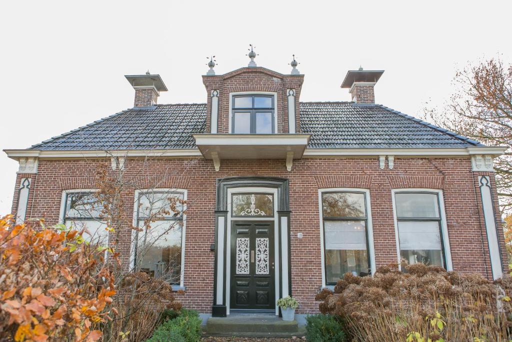 SuameerDe Friese Wouden的红砖房子,有黑色的门