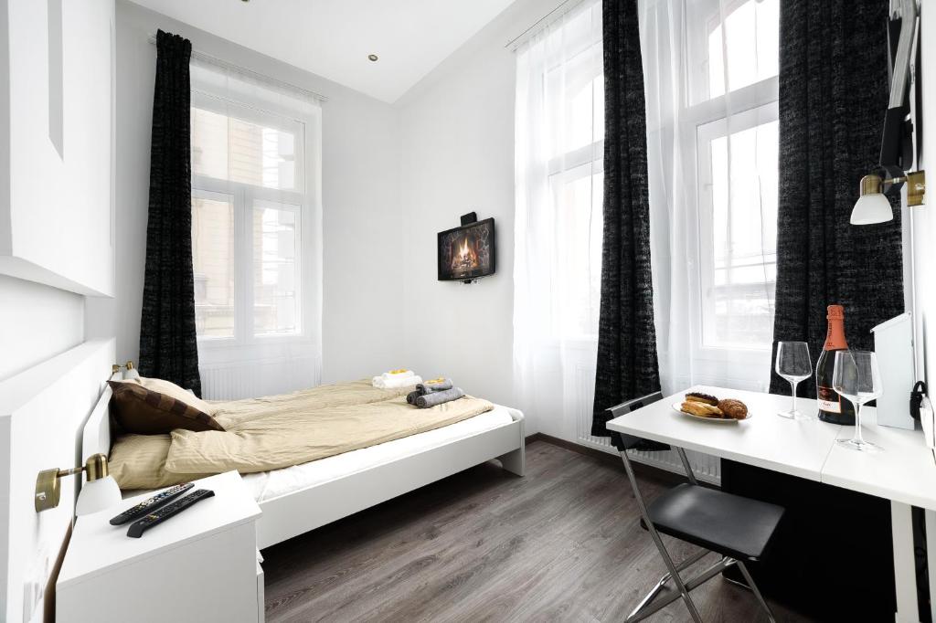 布达佩斯Annabelle Downtown Apartments的白色卧室配有床和书桌