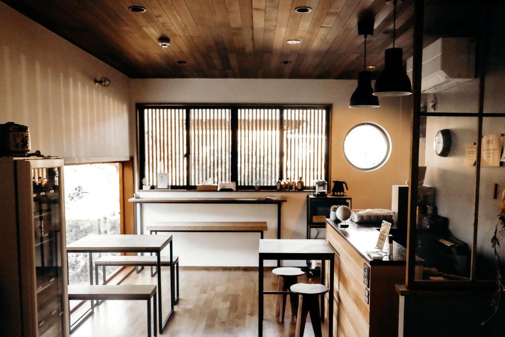 中津川市Guesthouse Nedoko的厨房配有2张桌子和椅子,设有窗户。