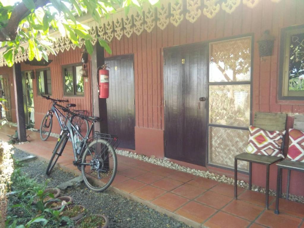 乌汶Rim Than View Resort的停在房子前面的自行车