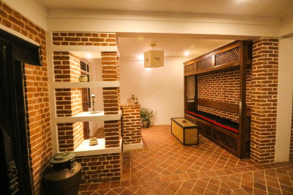 帕坦Chibha Classic Inn的一间设有砖墙和壁炉的客房