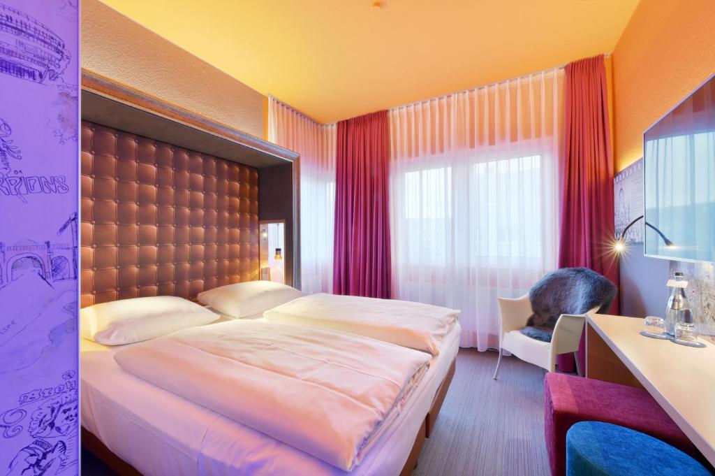 汉诺威威恩奈科XL设计酒店&国会中心的一间卧室设有一张大床和一个窗户。