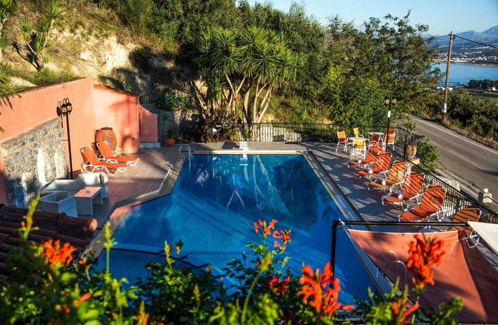 耶奥伊乌波利斯阿尔奇昂酒店的一个带橙色躺椅的游泳池以及一座房子