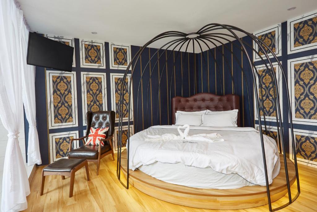 麻坡DREAM LUXURY HOTEL的一间卧室配有黑色和金色的天蓬床和椅子