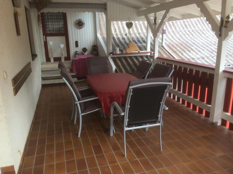 奥伯基希Ferienhaus Wunsch的门廊上配有桌椅的天井