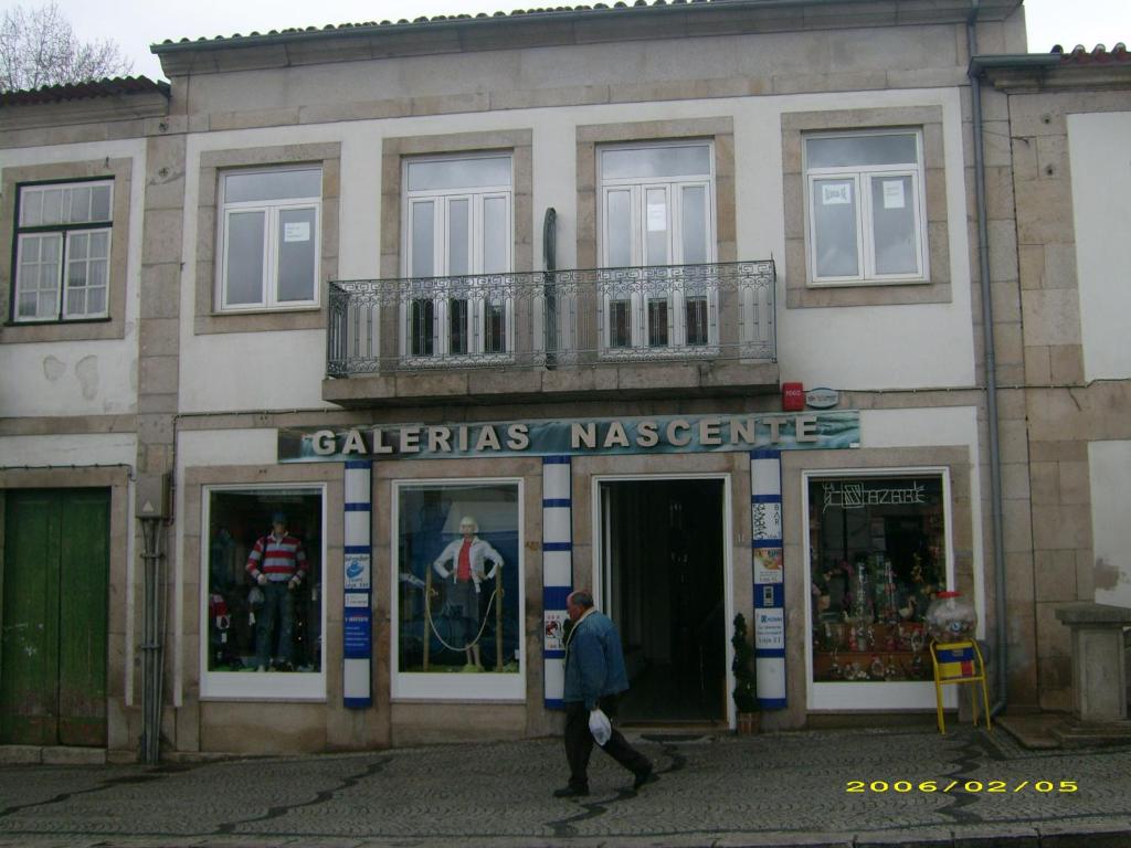 阿利若Alojamento Galerias Nascentes的站在建筑物前走的人