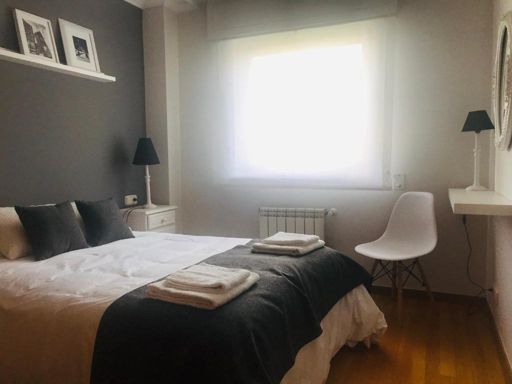 圣地亚哥－德孔波斯特拉Descanso do Sar的一间卧室配有一张床,上面有两条毛巾