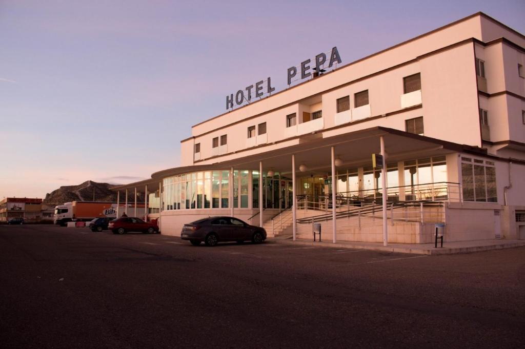 Villafranca de EbroHotel Pepa的前面有车辆停放的酒店