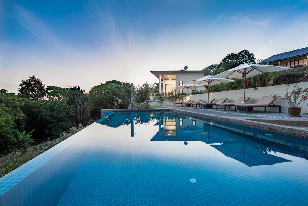 巴东马士力Ranis Lodge的一座房子前面的蓝色海水游泳池