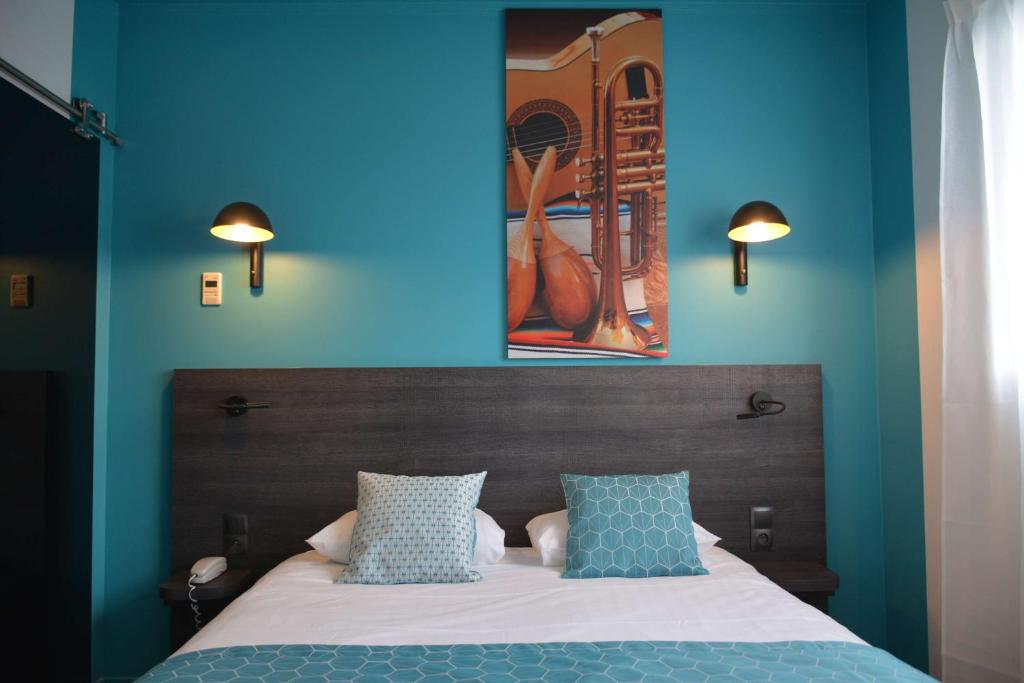 圣埃尔布兰Best Western Hotel Atlantys Zenith Nantes的一间卧室设有蓝色的墙壁和一张带枕头的床。
