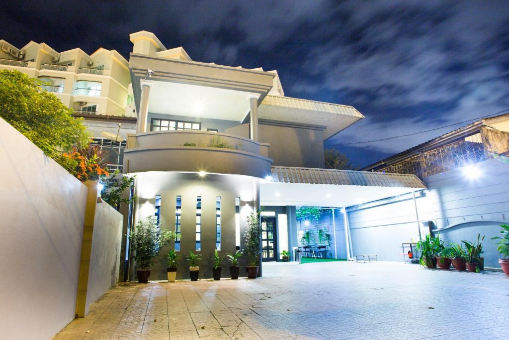 峇都丁宜G Beach Front Villa的一座白色的大建筑,晚上有庭院