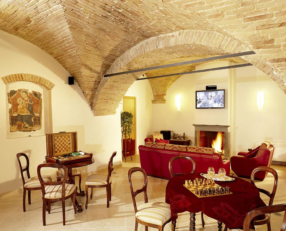 福利尼奥意大利酒店的客厅配有沙发和带国际象棋的桌子