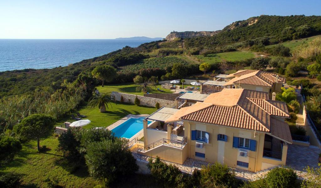 阿里拉斯Panorama Villas的享有带游泳池和大海的房屋的空中景致