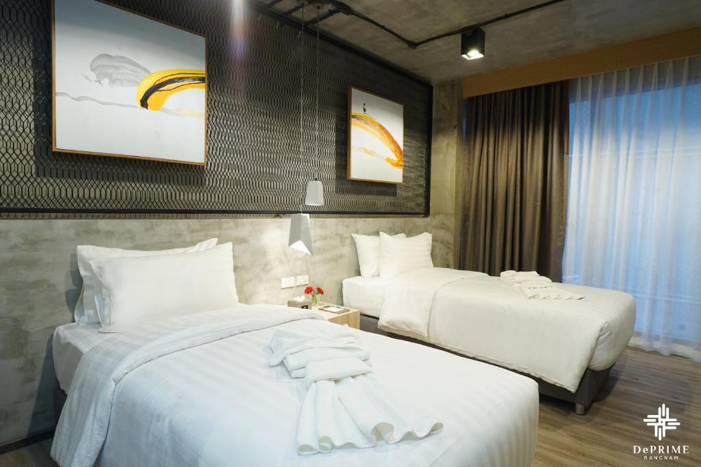 曼谷De Prime Rangnam Hotel的酒店客房,配有两张带白色床单的床