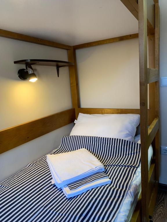乌日霍罗德Hostel Gulliver的床上铺有蓝色和白色条纹床单