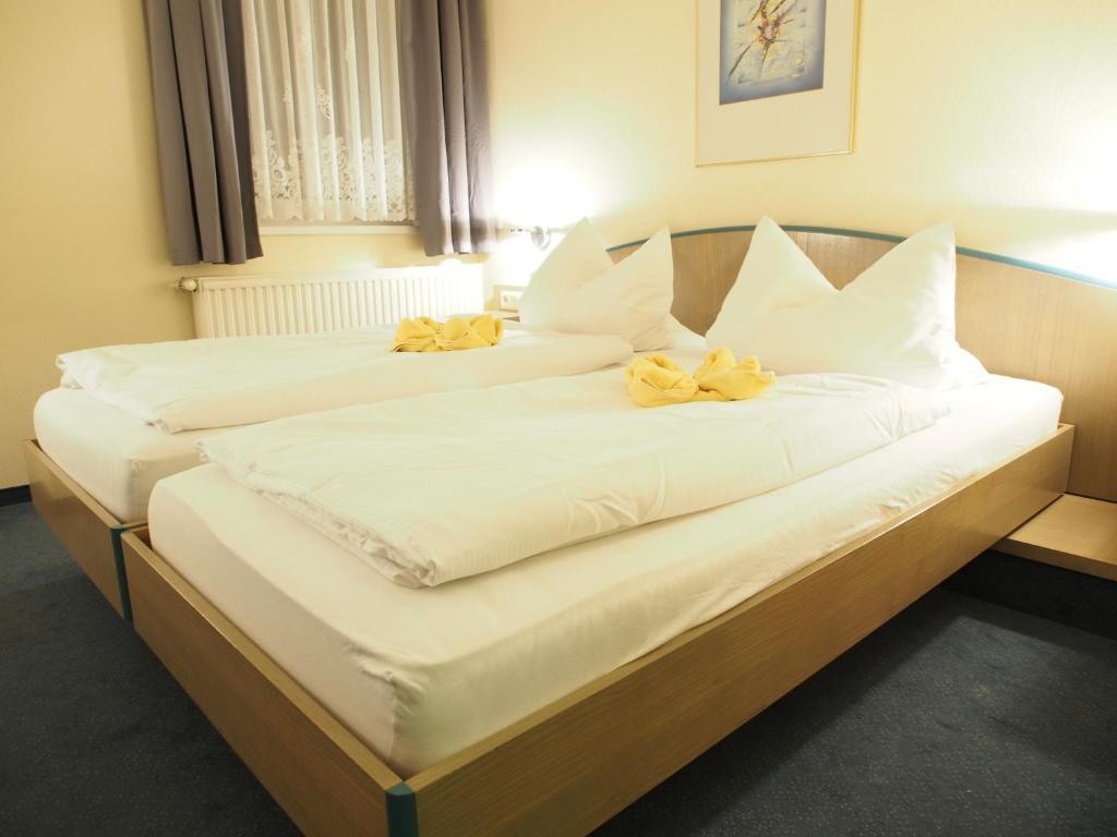 奥滕多夫-欧克里拉Pension Ottendorf-Okrilla的两张位于酒店客房的床,上面有黄色的弓