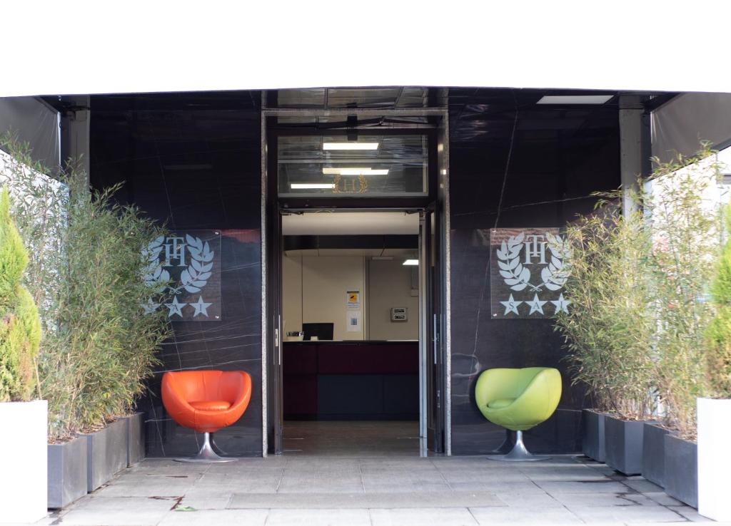 摩德纳奇碧酒店的一个带两把绿色和橙色椅子的办公室入口